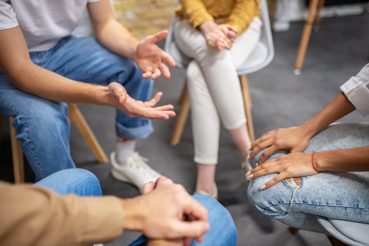 Talking circle. Close up picture of people sitting in a cirlce and talking